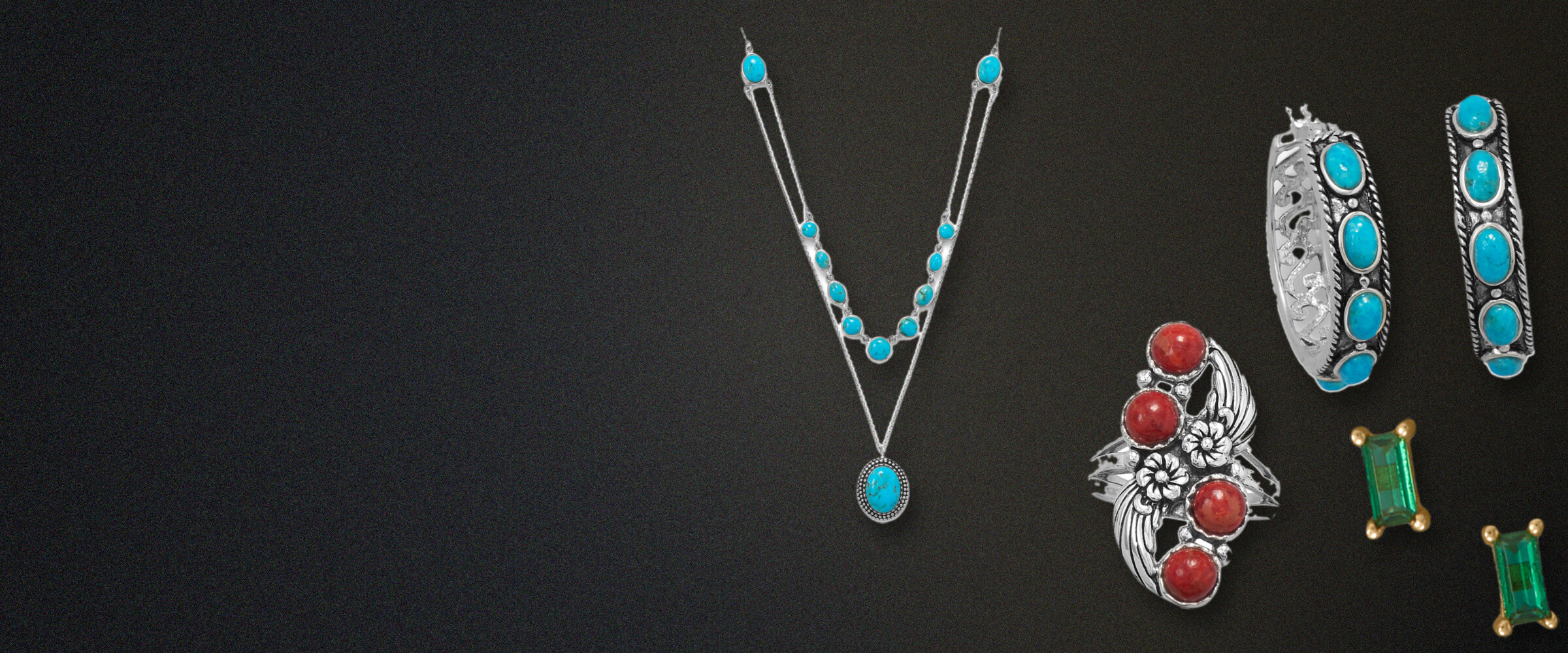 Colorful fashion jewelry on dark slate: a turquoise layered necklace, turquoise hoop earrings, a red coral ring and green baguette stud earrings